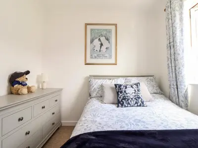 a bedroom with a bed and a dresser at Charleston Cottage in Falmouth
