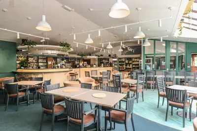 a restaurant with tables and chairs and a bar at Charleston Cottage in Falmouth