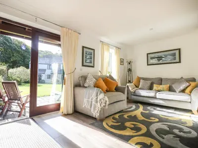 a living room with a couch and a sliding glass door at Charleston Cottage in Falmouth
