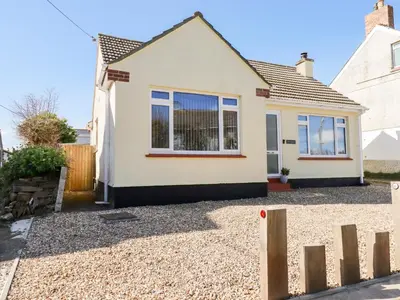 a white house with a fence in front of it at Seawynds in Newquay