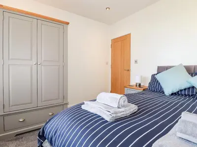 a bedroom with a bed with towels on it at Seawynds in Newquay