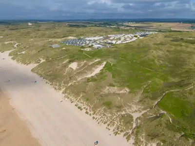 an aerial view of a beach with houses and condos at St Ives Bay Beach Resort in Phillack