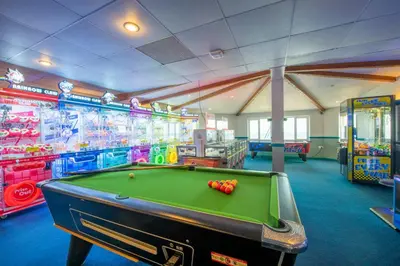 a room with a pool table and many games at St Ives Bay Beach Resort in Phillack