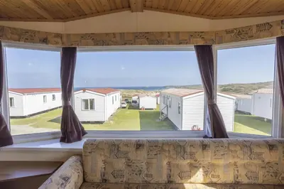 a large window in a room with a couch at St Ives Bay Beach Resort in Phillack