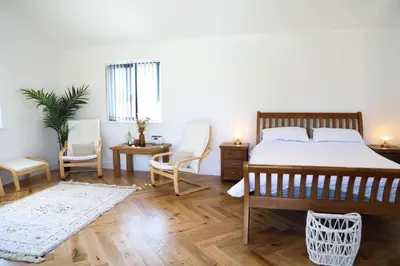 a bedroom with a bed and two chairs and a table at Mortham in St Merryn