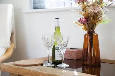 a table with two glasses and a bottle of wine at Mortham in St Merryn