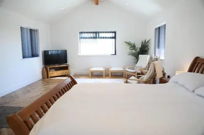 a bedroom with a large bed and a television at Mortham in St Merryn