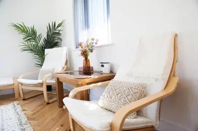 a living room with a rocking chair and a table at Mortham in St Merryn
