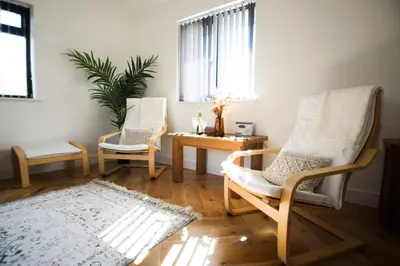 a living room with two chairs and a table at Mortham in St Merryn