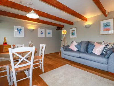 a living room with a couch and a table at 4 Trenhaile Terrace in Truro