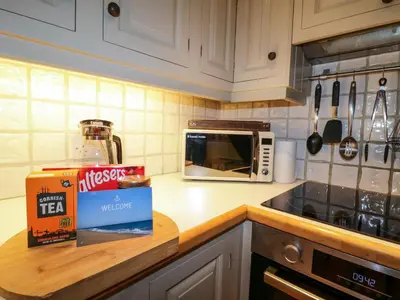 a kitchen counter with a box of cereal and a microwave at 4 Trenhaile Terrace in Truro