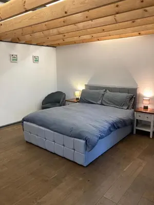 a bedroom with a large bed and a chair at The Bolt Hole - Looe. in Looe