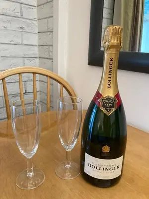 a bottle of champagne and two glasses on a table at The Bolt Hole - Looe. in Looe