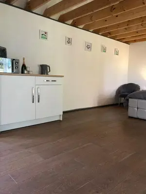 a living room with white walls and wooden floors at The Bolt Hole - Looe. in Looe