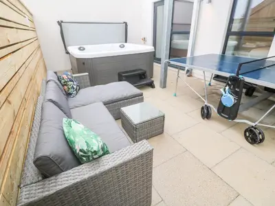 a living room with a couch and a table and a tub at Porth Cove in Newquay