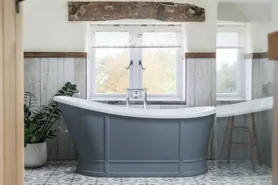 a large bath tub in a bathroom with a window at Glebe Cottage, Little Petherick, near Padstow in Little Petherick