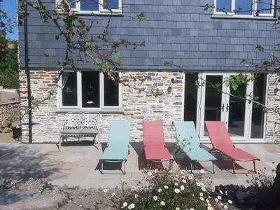 a group of chairs and a bench in front of a building at Glebe Cottage, Little Petherick, near Padstow in Little Petherick
