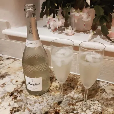 a bottle of champagne and two glasses on a table at Glebe Cottage, Little Petherick, near Padstow in Little Petherick
