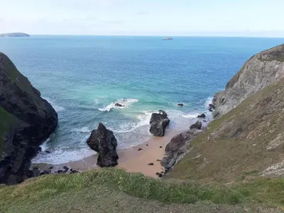 a beach with two large rocks in the ocean at Glebe Cottage, Little Petherick, near Padstow in Little Petherick