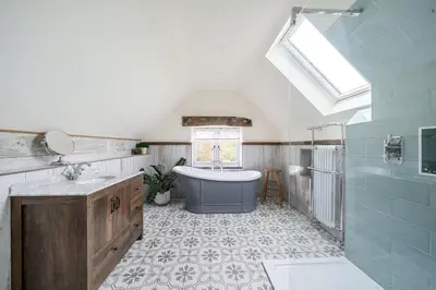 a bathroom with a tub and a sink and a window at Glebe Cottage, Little Petherick, near Padstow in Little Petherick