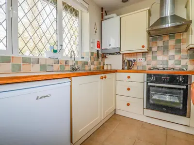 a kitchen with white cabinets and a stove top oven at Little Oaklands in Lostwithiel