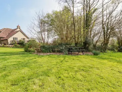 a park bench sitting in the middle of a yard at Little Oaklands in Lostwithiel
