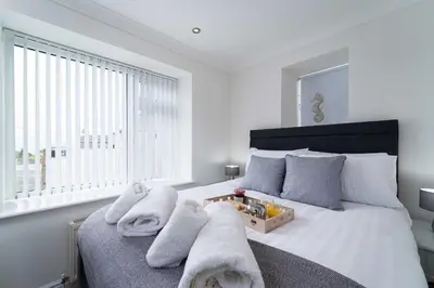 a bedroom with a bed with towels on it at The Barn in St Ives