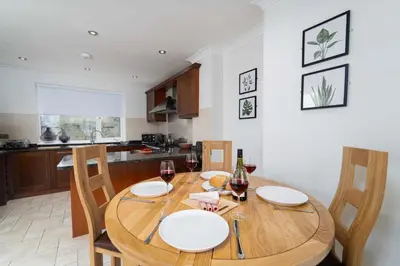 a kitchen with a wooden table with glasses of wine at The Barn in St Ives