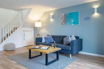 a living room with a blue couch and a table at Coverack in Budock Water
