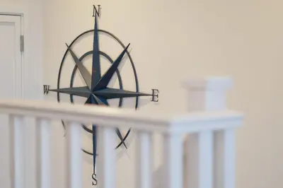a clock on top of a white wall at Coverack in Budock Water