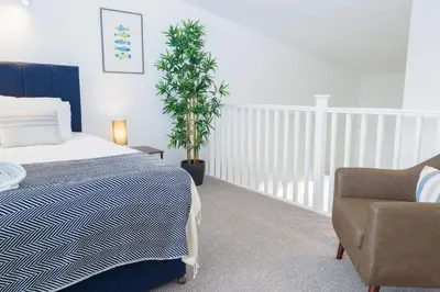 a bedroom with a bed and a chair and a plant at Helford in Mawnan