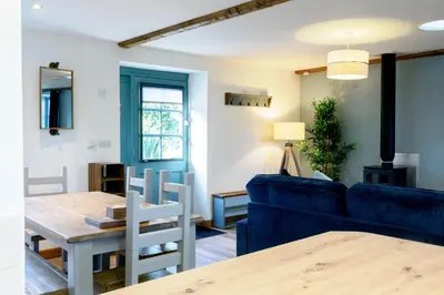 a living room with a blue couch and a table at Lamorna in Mawnan Smith