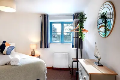 a bedroom with a bed and a window at Lamorna in Mawnan Smith