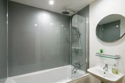 a bathroom with a shower and a sink and a mirror at Lamorna in Mawnan Smith