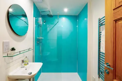 a bathroom with a blue shower and a sink at Lamorna in Mawnan Smith