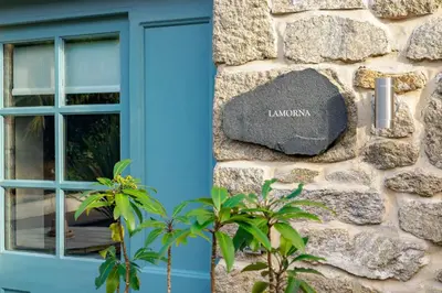 a stone sign on the side of a building with a window at Lamorna in Mawnan Smith