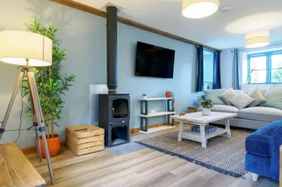 a living room with a couch and a fireplace at Lamorna in Mawnan Smith