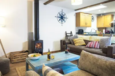 a living room with a couch and a wood stove at Manacles in Mawnan