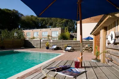 a blue umbrella sitting on a table next to a pool at Manacles in Mawnan