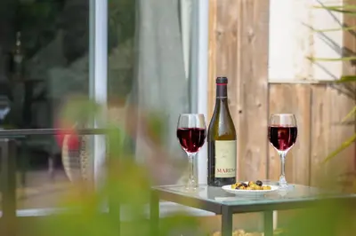 a bottle of wine and two glasses on a table at Mousehole in Mawnan