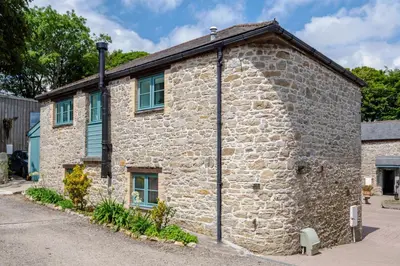 an old stone house with a stone wall at Newlyn in Budock Water