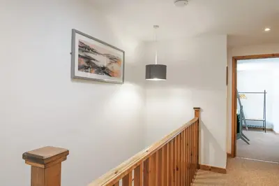 a staircase with white walls and a picture on the wall at Newlyn in Budock Water