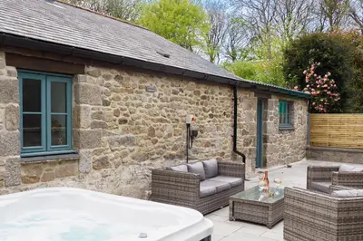 a bath tub sitting outside of a stone house at Pendeen in Falmouth