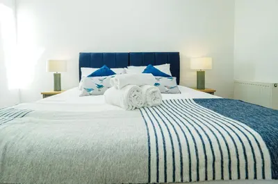 a bedroom with a large bed with towels on it at Pendeen in Falmouth