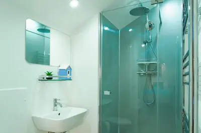 a bathroom with a sink and a glass shower at Porthallow in Budock Water