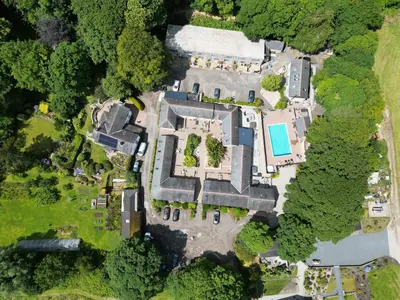 an overhead view of a mansion with a pool at Porthallow in Budock Water