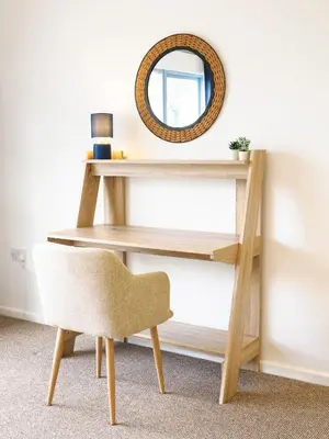 a dressing table with a chair and a mirror at Sennen in Budock Water