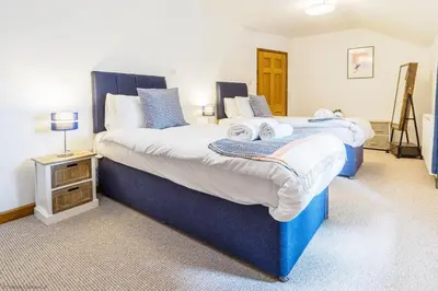 a bedroom with two beds with towels on them at St Keverne in Budock Water