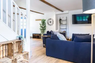 a living room with a blue couch and a clock at St Keverne in Budock Water