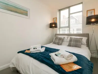 a bedroom with a bed with towels on it at Lighthouse Lofts - St Anthony in Camborne